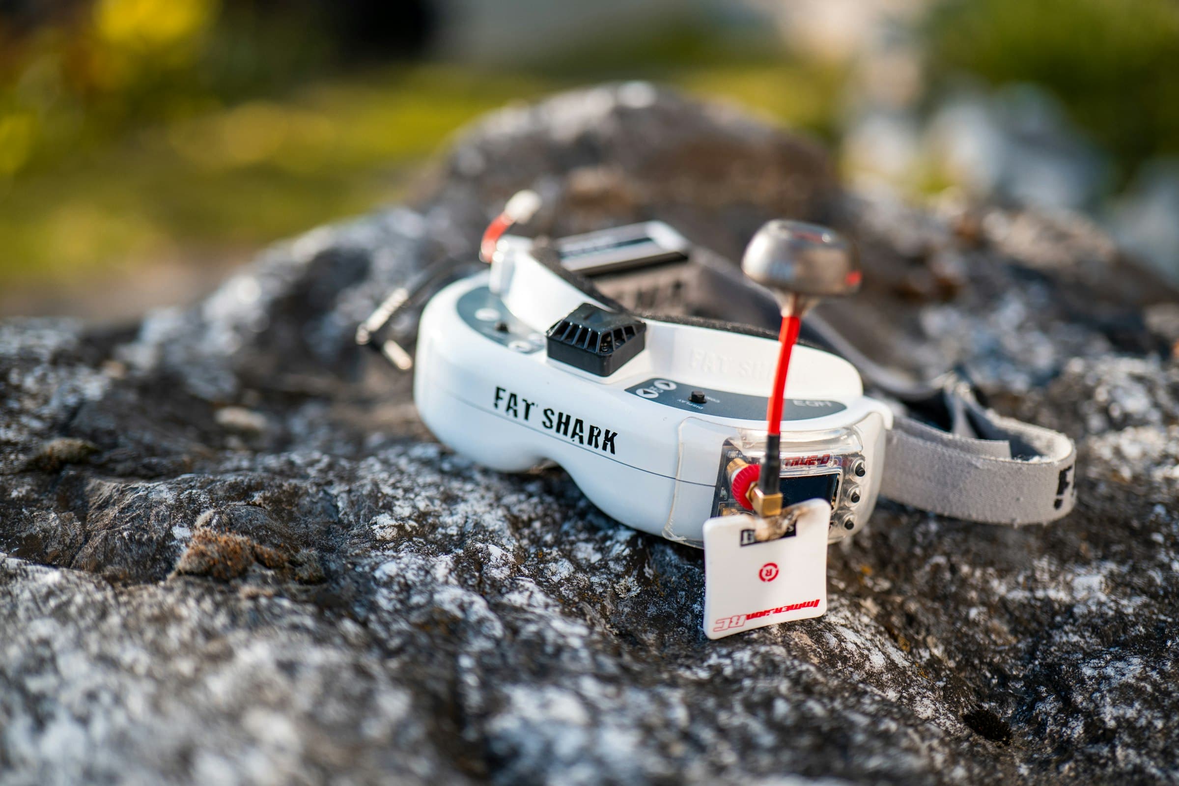 FPV racing goggles resting quietly on a rock in natural evening light